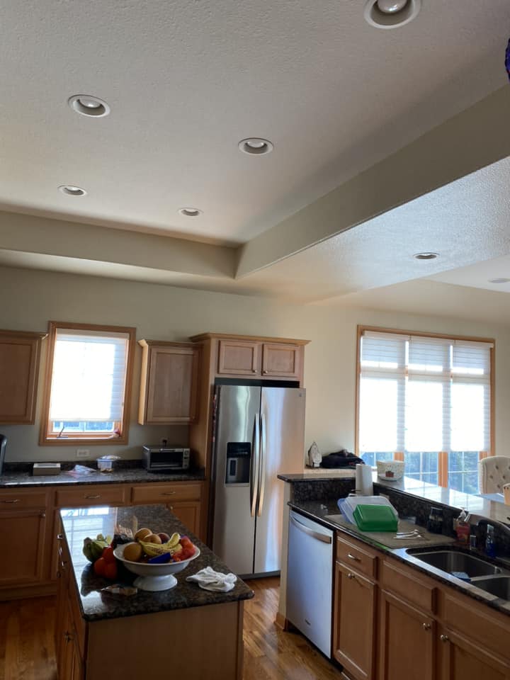 Existing kitchen before renovation with honey-oak cabinets, dark granite countertops, and stainless refrigerator